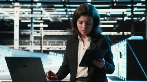 Data center female admin uses device and AR simulation to conduct security audit Stock Footage 328334261