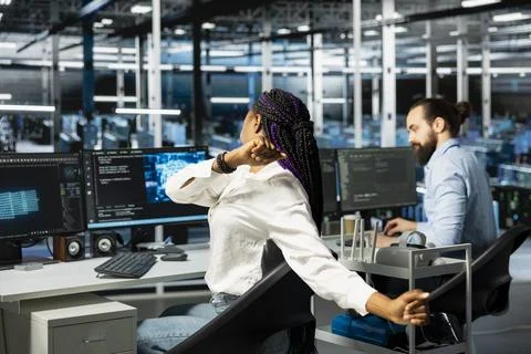 Data center female engineer stretching back to combat sedentary fatigue Stock Photos