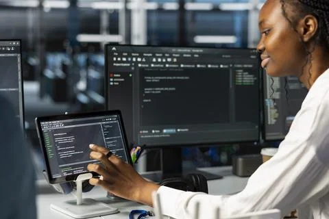 Data center female technician using tablet, coding, managing systems Stock Photos