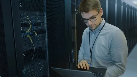 In Data Center IT Engineer Stands Before Working Server Rack Doing Routine Work Stock Footage 101277821