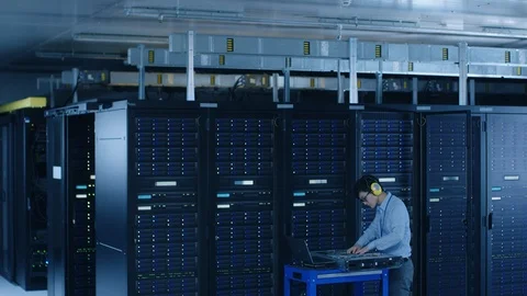 In Data Center: IT Engineer Wearing Protective Muffs Installs New Hardware Stock Footage 101184799