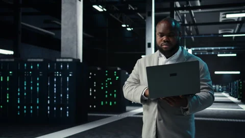 Data center IT expert reviewing performance dashboards of equipment rigs Stock Footage 311898838