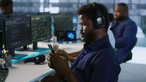 Data center IT expert texting on smartphone, taking break 스톡 사진