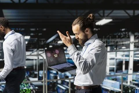 Data center male developer frustrated by critical error affecting laptop Stock Photos