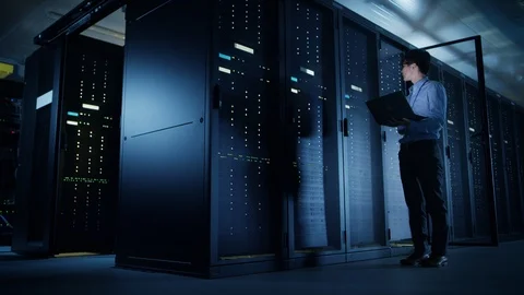 In Data Center: Male IT Technician Running Maintenance Programme on a Laptop Stock Footage 101187053