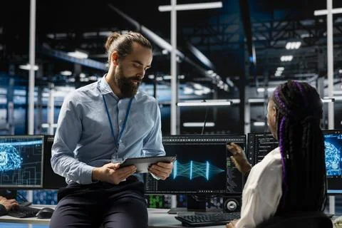Data center manager and intern adjusting AI model parameters 库存照片