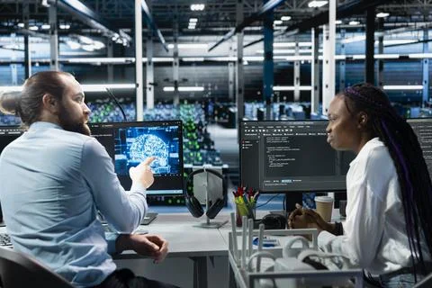 Data center manager and intern monitoring AI applications Stock Photos