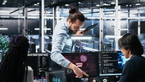 Data center manager coordinates programmers fixing critical error while using AI Stock Footage 313637654