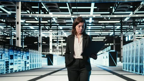 Data center manager inspecting blue wireframe mesh hardware rackmounts Stock Footage 329323912