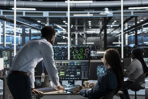 Data center manager supervises engineer using AI visual programming Stock Photos