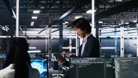 Data center manager supervising developer using device to monitor neural network Stock Footage 313635018