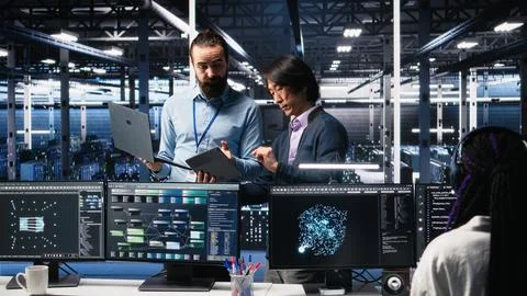 Data center manager supervising developer using device to monitor neural network Stock Photos