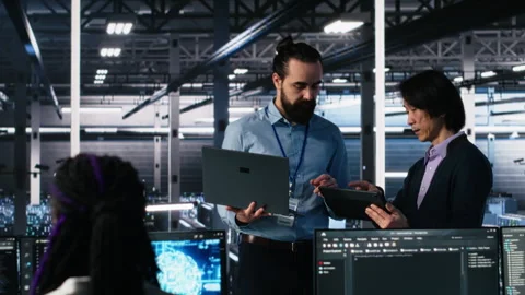 Data center manager supervising work done by programmers on neural network Stock-Footage 313569677