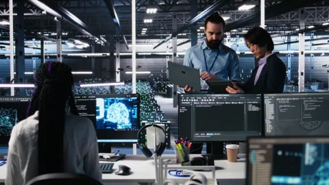 Data center manager supervising work done by programmers on neural network Stock Footage 313640345