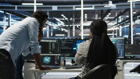 Data center manager supervising worker deploying AI solutions Stock Photos