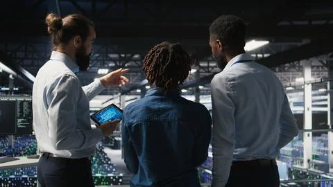 Data center manager talking with workers doing maintenance on AI supercomputers 스톡 사진