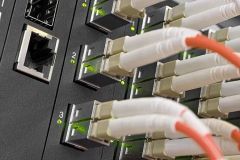 Data center, network panel, switch and connected multi-colored cables Stock Photos