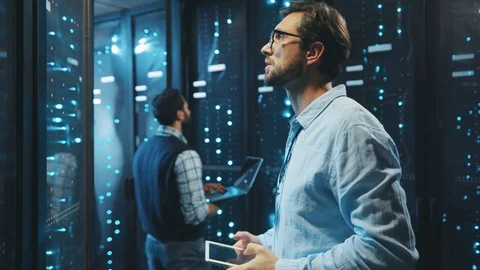Data center professional team inspecting super computer in server room. Bearded Stock Footage 119279340