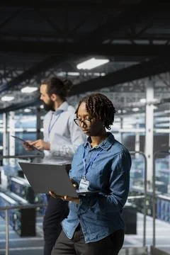 Data center programmer on industrial platform checking lines of code Stock Photos