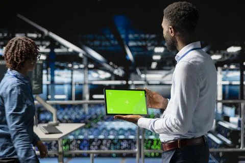 Data center programmer on industrial platform using green screen tablet Foto stock