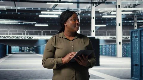 Data center programmer monitors data center metrics on tablet Foto stock