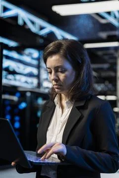 Data center programmer using laptop to review equipment diagnostics 스톡 사진