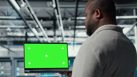 Data center programmer working on green screen laptop, updating storage Stock Footage 311896875