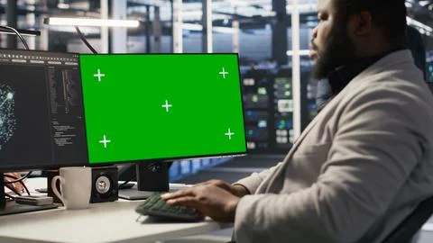 Data center programmer working on green screen desktop PC Stock Photos