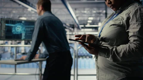 Data center programmers check AI dashboard using tablet, doing systems review Video stock 314684170