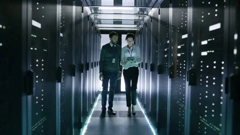 In Data Center/ Server Room IT Engineer Consults with Female Chief Engineer  Stock Footage 73667070