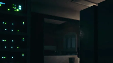 Data center showing server lights at night with a computer desk nearby Stock Footage 345007431