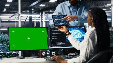 Data center software developer managing AI systems using green screen PC Stock Photos