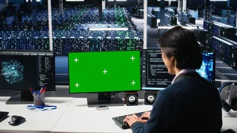 Data center software developer managing AI systems using green screen PC Stock Photos