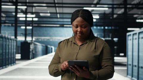 Data center software developer monitors data center metrics on tablet Stock Footage 317204636