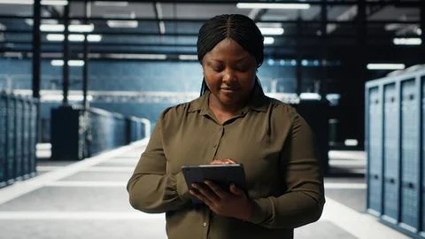 Data center software developer monitors data center metrics on tablet 스톡 사진