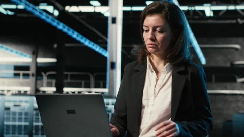Data center software developer optimizing server load balancing using laptop Stock Footage 329326985