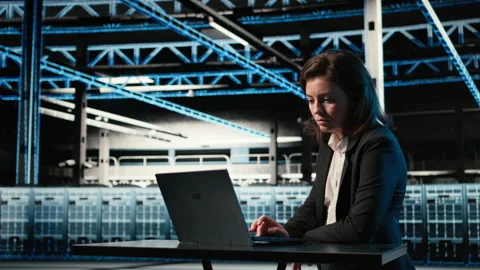 Data center software developer optimizing server load balancing using laptop Stock Footage 329329226