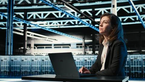 Data center software developer optimizing server load balancing using laptop Stock Photos