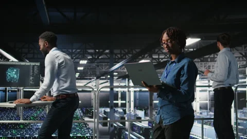 Data center software developers using devices to review AI LLM visualizations Stock Footage 310787414