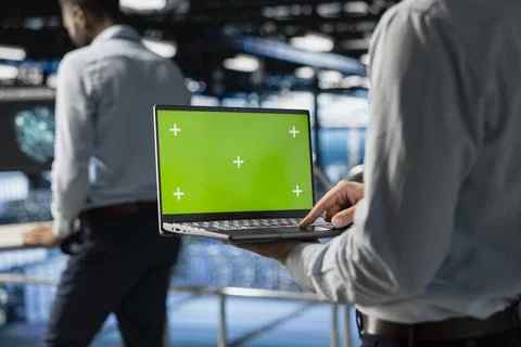 Data center staff using green screen mockup on laptop screen 写真素材