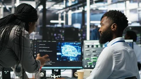 Data center supervisor overseeing work done by engineer using deep learning Stock Photos