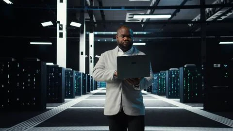 Data center system administrator coding on laptop, doing software updates Stock-Fotos