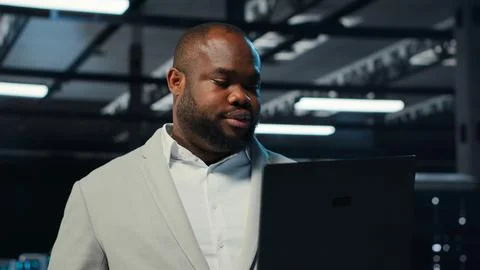 Data center system administrator coding on laptop, doing software updates Stock Photos