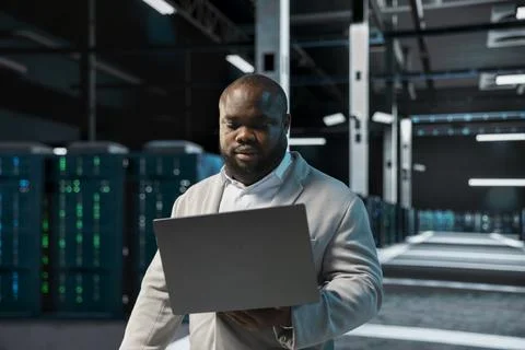Data center system administrator running error checking utilities on laptop Stock Photos