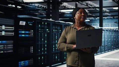 Data center system administrator uses laptop to develop disaster recovery plans Stock Photos