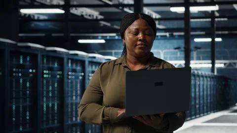 Data center system administrator uses laptop to develop disaster recovery plans Stock Photos