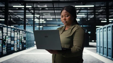 Data center system administrator using laptop to ensure error free rigs Stock Footage 317204171