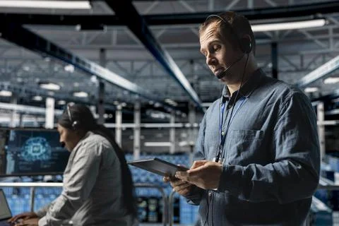 Data center system administrator using headset mic, providing remote diagnostics 写真素材