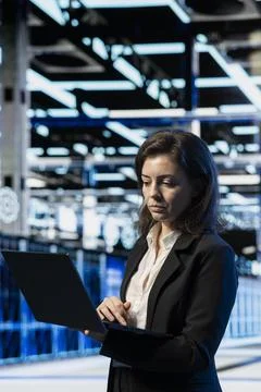 Data center system administrator using laptop software to do maintenance Stock Photos