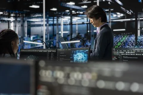 Data center system administrators using PC, adjusting AI model parameters Stock Photos